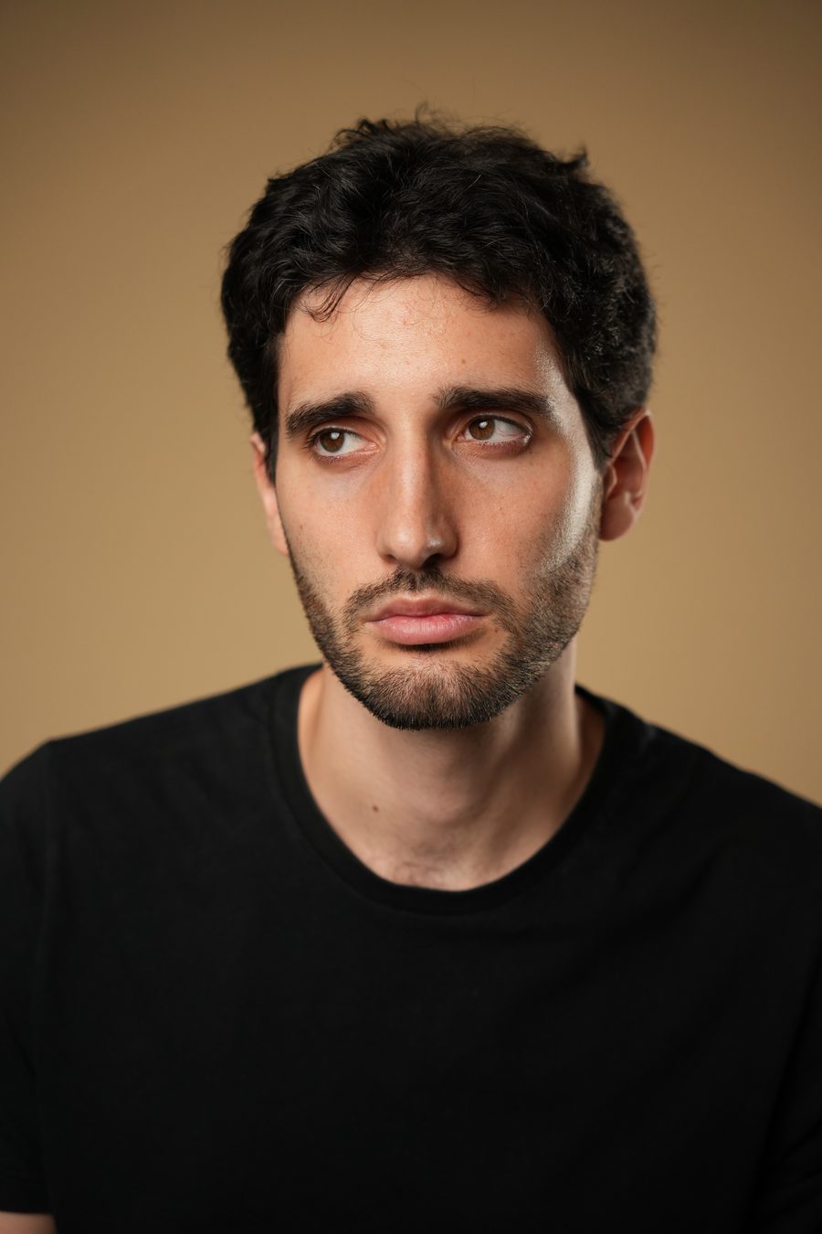 Jovan Penezić, black t-shirt, looking off camera.